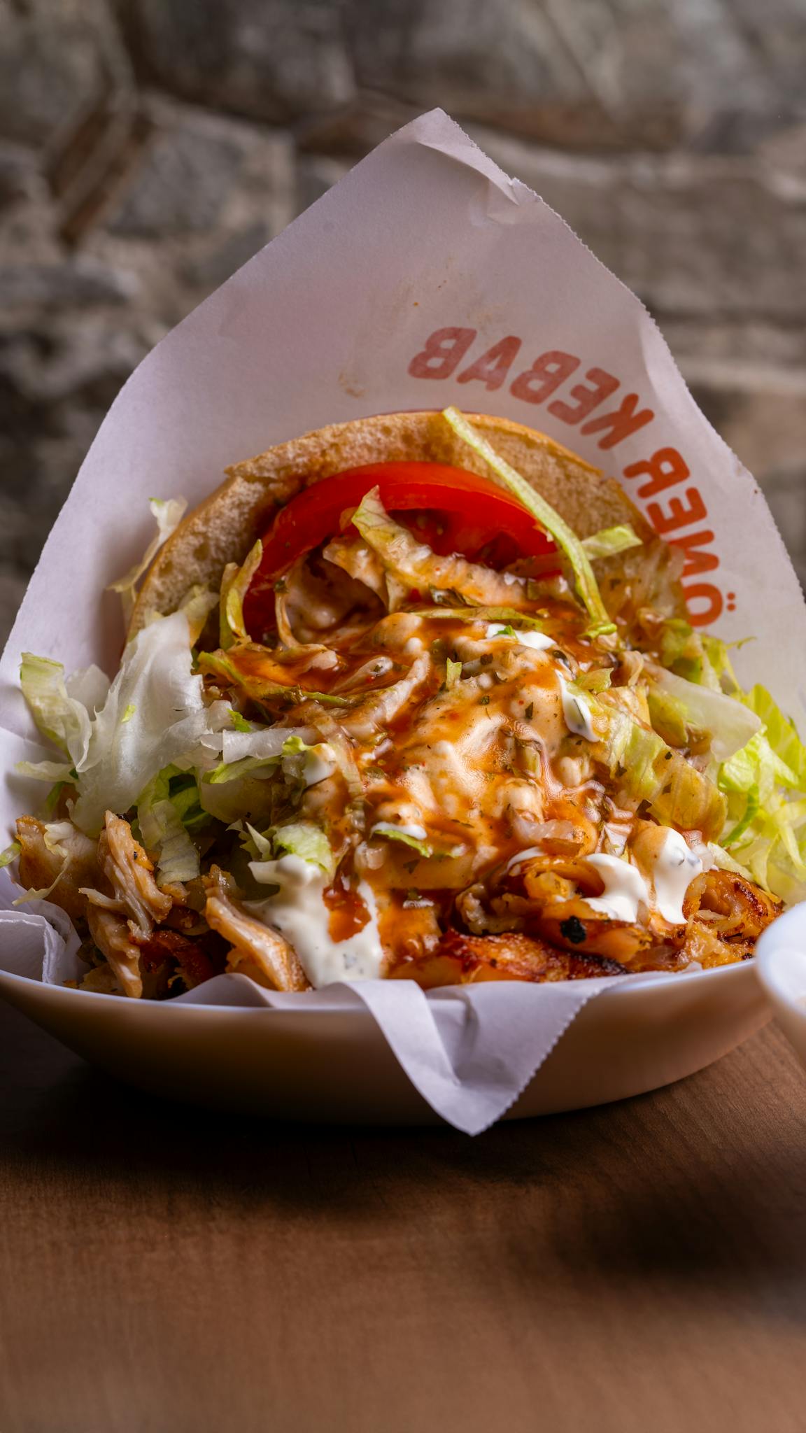 Close-up of a juicy doner kebab with fresh lettuce and tomato, perfect for a tasty meal.