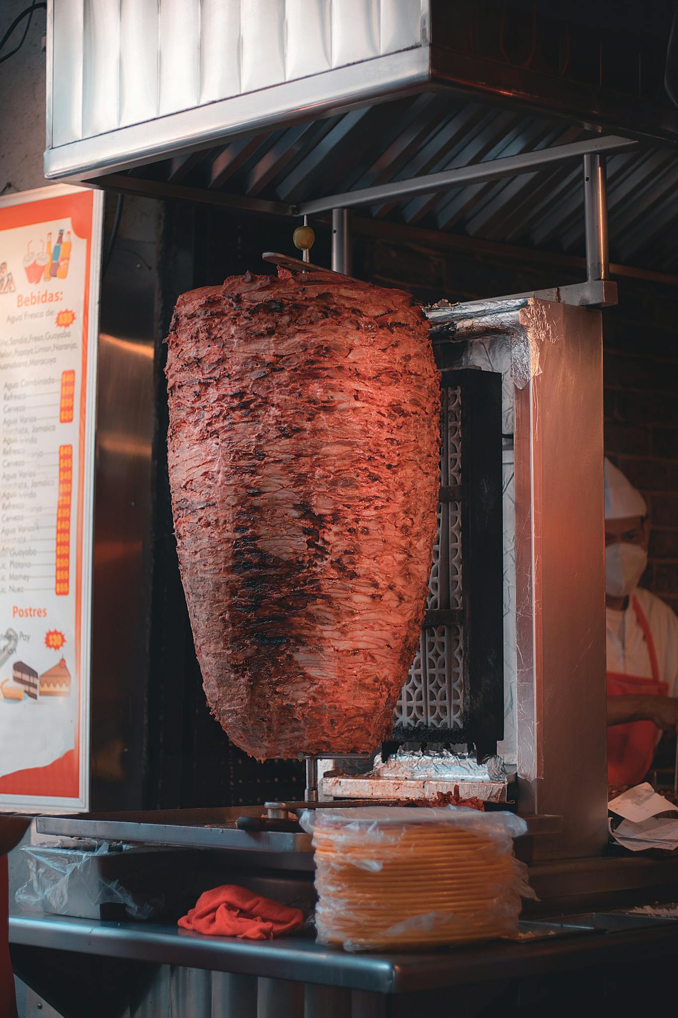 Delicious shawarma rotating on a vertical grill at a street food restaurant.