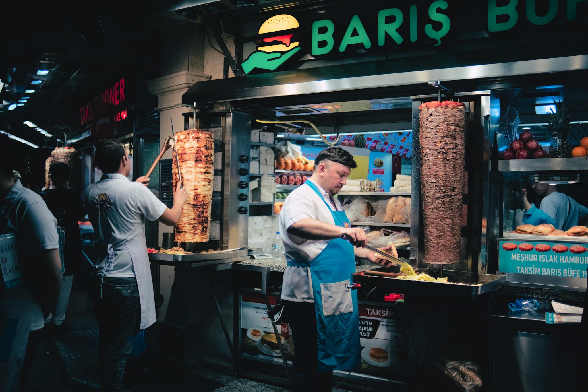 Delicious Turkish doner kebabs being prepared at a vibrant night street food stall in Istanbul.