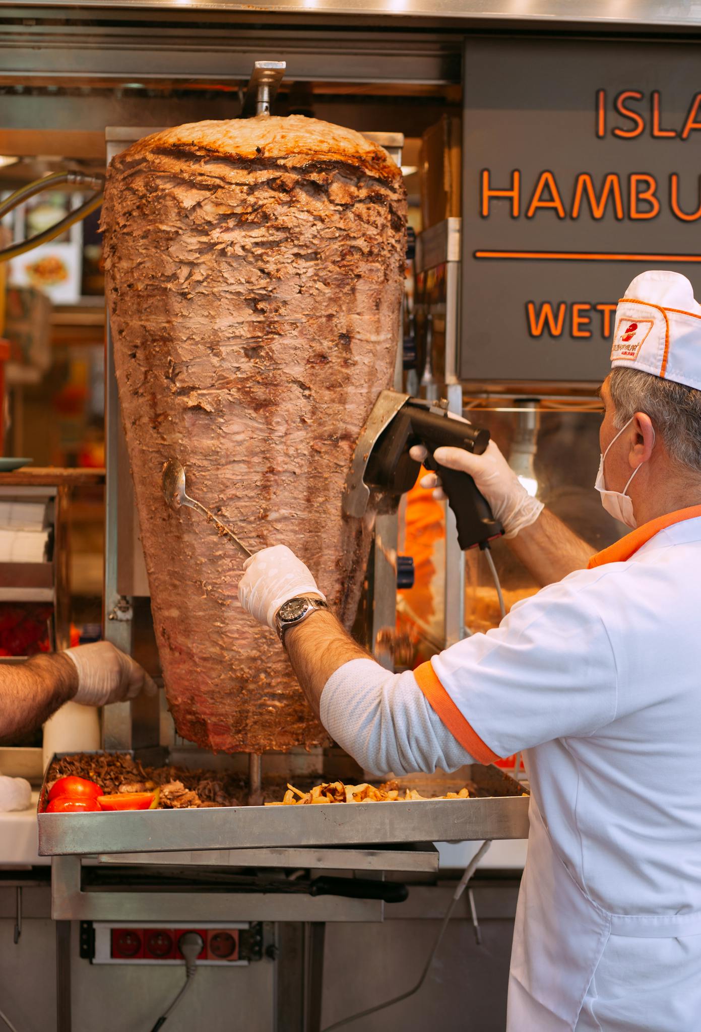 Street vendor slicing delicious doner kebab in Istanbul's bustling markets, a taste of traditional Turkish street food.